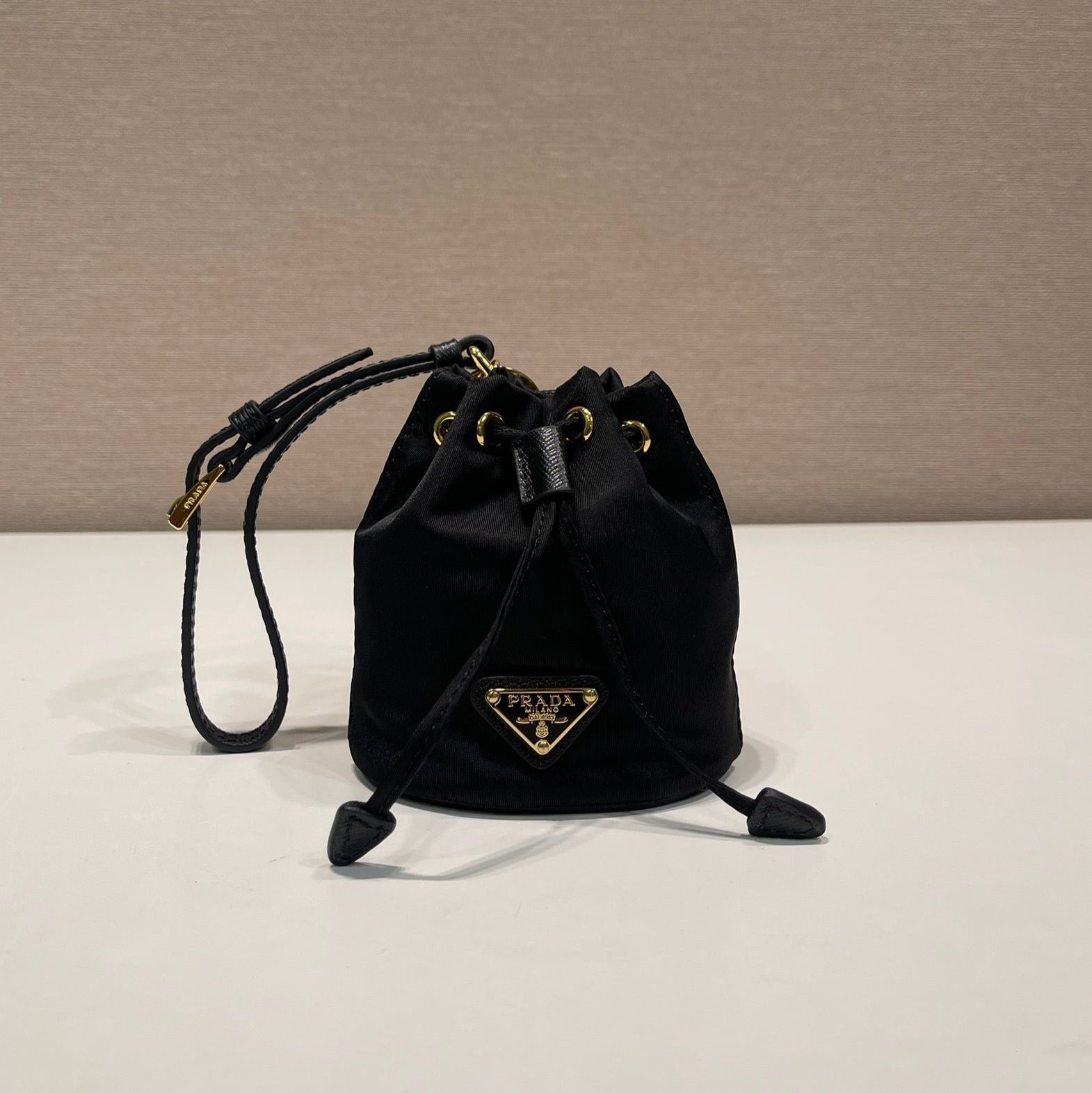 {Style No: QMC1V6OL} MINI BUCKET BAG 10 IN BLACK RE-NYLON AND SAFFIANO LEATHER STRAP